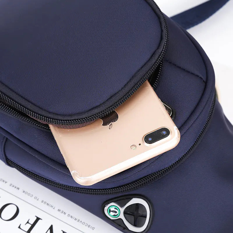 Navy blue sport shoulder bag with zipper pocket and headphone jack.