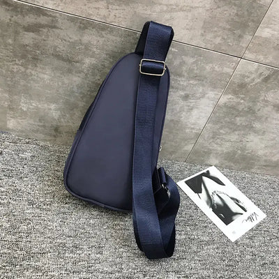 Navy blue sport shoulder bag with headphone jack for outdoor use.