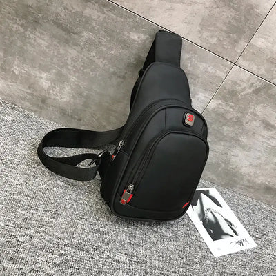 Sport shoulder bag with headphone jack, black, on gray carpet, single strap, sleek design.